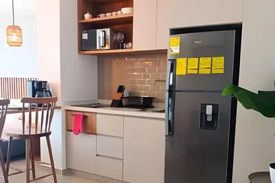 a kitchen with a black refrigerator next to a table at Lujoso Apart Studio frente al Mar in Cartagena de Indias