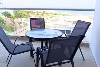 two chairs and a table with a laptop on a balcony at Playa, Vista al mar y Comodidad, ubicación perfecta in Cartagena de Indias