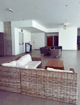 a living room with a large wicker couch at Chic Apartment Near It All in Cartagena de Indias