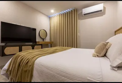 a hotel room with a bed and a flat screen tv at Impresionante vista Dominique 2 suites in Cartagena de Indias