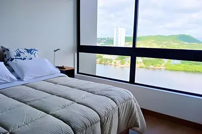 a bedroom with a large window overlooking a river at Luxury 2B, stunning View 4 Blocks from walled City in Cartagena de Indias