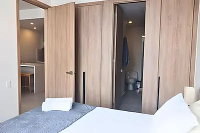 a bedroom with wooden sliding doors and a bed at Lujo y comodidad Frente al Mar in Cartagena de Indias