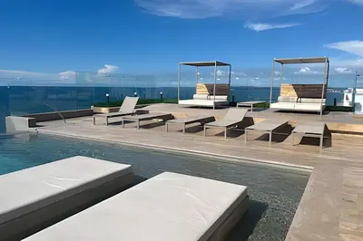 a swimming pool with lounge chairs and the water at Brand New Apt Pool & City Views in Cartagena de Indias