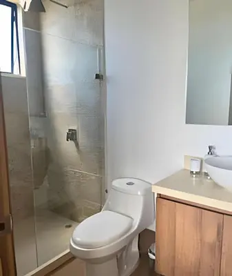 a bathroom with a toilet and a glass shower at Brand New Apt Pool & City Views in Cartagena de Indias