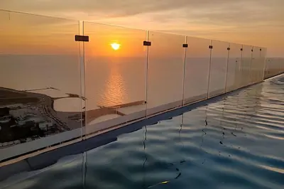 a infinity pool with the sunset in the background at Brand New Apt Pool & City Views in Cartagena de Indias