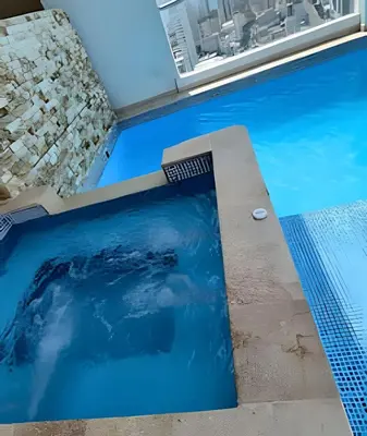 a swimming pool with blue water in a building at Bay View Duplex in Bocagrande in Cartagena de Indias