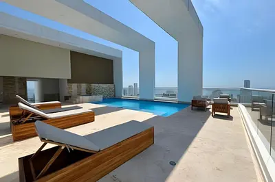 a large room with a pool and chairs on a building at Bay View Duplex in Bocagrande in Cartagena de Indias