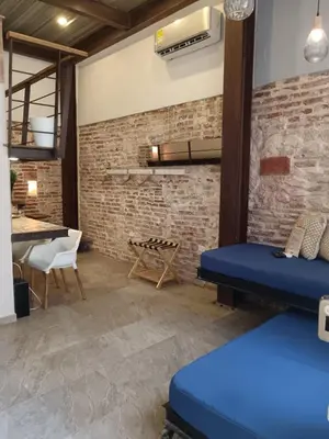 a room with a brick wall and blue beds at Hermoso apartamento con patio privado in Cartagena de Indias