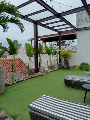 a patio with green grass and awning with plants at Hermoso apartamento con patio privado in Cartagena de Indias