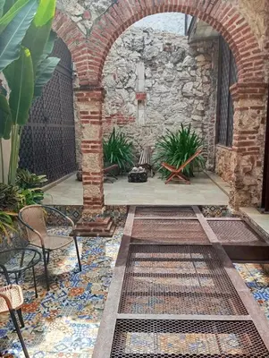 an outdoor patio with an archway and plants at Hermoso apartamento con patio privado in Cartagena de Indias