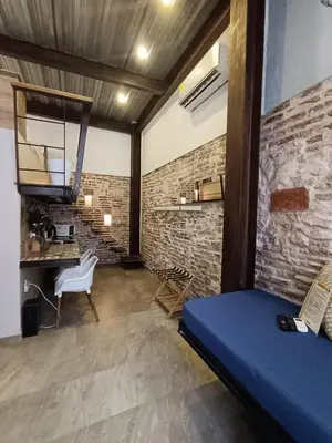 a room with a blue bed and a brick wall at Hermoso apartamento con patio privado in Cartagena de Indias