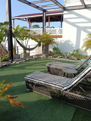 a patio with a chair and table on a green floor at Hermoso apartamento con patio privado in Cartagena de Indias