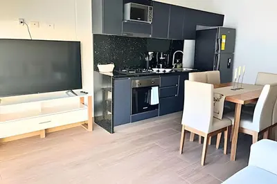 a kitchen and dining room with a table and a tv at Stuning view to Walled city & Beach, King size bed in Cartagena de Indias