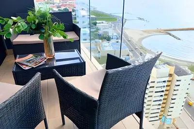 a balcony with chairs and a table with a view of a city at Oceanfront Gem by Walled City, Spectacular Views in Cartagena de Indias