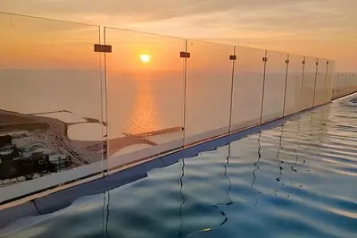 a infinity pool with the sunset in the background at Oceanfront Gem by Walled City, Spectacular Views in Cartagena de Indias