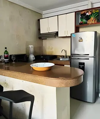 a kitchen with a counter with a refrigerator and a sink at Apto a pasos de la playa, ubicación perfecta in Cartagena de Indias