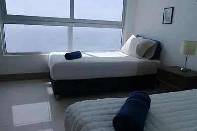 a bedroom with two beds and two large windows at Luxury 2B apartment, Amazing View in Cartagena de Indias