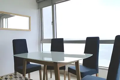 a dining room with a glass table and blue chairs at Espectacular vista en la mejor zona del Laguito in Cartagena de Indias