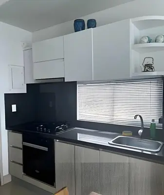 a kitchen with white cabinets and a black counter top at Ocean Majesty, Luxury Haven close to Walled City in Cartagena de Indias