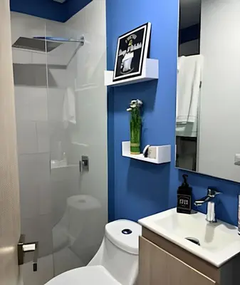a bathroom with a white toilet and a blue wall at Charming Loft near the Beach in Cartagena de Indias