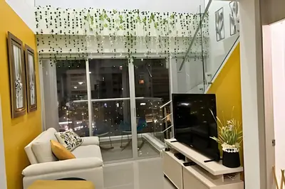 a living room with a white couch and a television at Charming Loft near the Beach in Cartagena de Indias