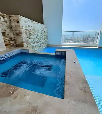 a swimming pool in a building with a large window at Charming Loft near the Beach in Cartagena de Indias