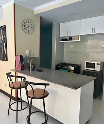 a kitchen with two bar stools and a counter at Lindo apto con salida directa a la playa in Cartagena de Indias