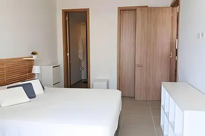 a bedroom with a white bed and a wooden door at Lujo y privacidad, Vista y salida directa al mar in Cartagena de Indias