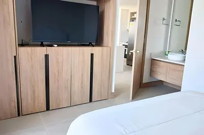 a bedroom with a television on a wooden cabinet at Lujoso, último piso con salida directa a la playa in Cartagena de Indias