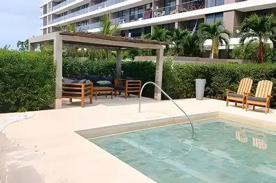 a swimming pool with a table and chairs next to a building at Lujoso, último piso con salida directa a la playa in Cartagena de Indias