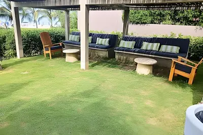 a patio with blue couches and chairs in a yard at Lujoso, último piso con salida directa a la playa in Cartagena de Indias