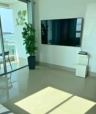 a living room with a tv and a table and a plant at Coastal Charm with Mesmerizing Seaside Views in Cartagena de Indias
