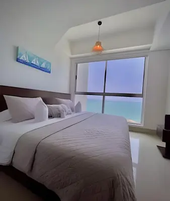 a bedroom with a large bed with a large window at Amazing Ocean View, 2B in Bocagrande in Cartagena de Indias