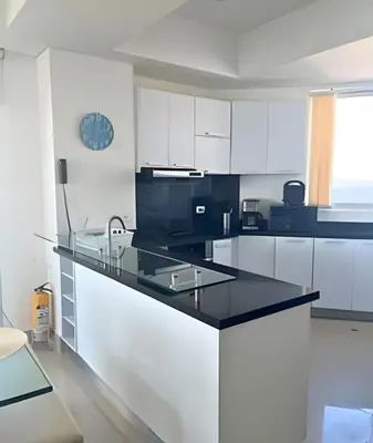 a kitchen with white cabinets and a black counter top at Amazing Ocean View, 2B in Bocagrande in Cartagena de Indias
