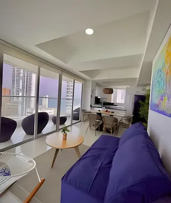 a living room with a purple couch and a table at Amazing Ocean View, 2B in Bocagrande in Cartagena de Indias