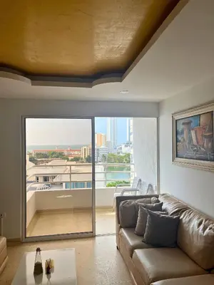 a living room with a couch and a large window at Bello apartamento con acceso directo a la playa in Cartagena de Indias