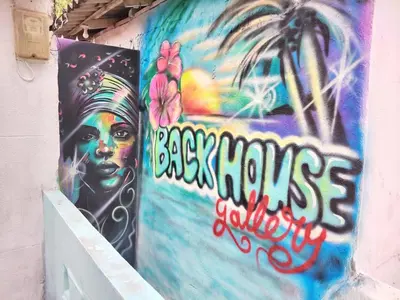 a wall with a painting of a woman on it at Backhouse gallery in Cartagena de Indias
