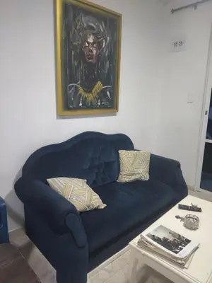 a blue couch in a living room with a table at Backhouse gallery in Cartagena de Indias