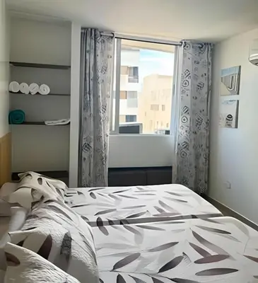a bedroom with a bed and a window at Precioso apto en el Laguito a pasos de la playa in Cartagena de Indias