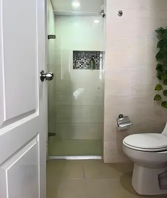 a bathroom with a toilet and a glass shower at Precioso apto en el Laguito a pasos de la playa in Cartagena de Indias