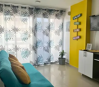 a living room with a blue couch and a curtain at Precioso apto en el Laguito a pasos de la playa in Cartagena de Indias
