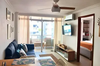 a living room with a blue couch and a bedroom at Precioso Apto a pasos de la playa, ubicación ideal in Cartagena de Indias