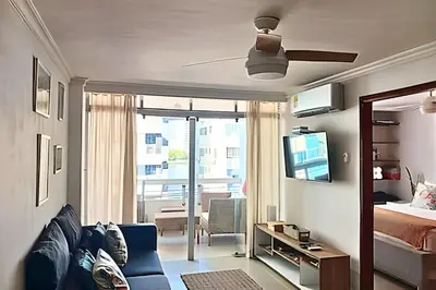 a bedroom with a bed and a living room with a ceiling fan at Precioso Apto a pasos de la playa, ubicación ideal in Cartagena de Indias