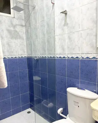 a blue tiled bathroom with a toilet and a shower at Casa lujosa cerca al mar en cartagena in Cartagena de Indias