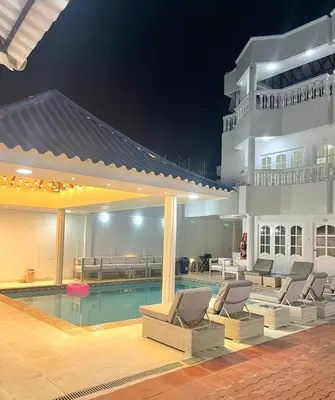 a swimming pool with lounge chairs next to a building at Casa lujosa cerca al mar en cartagena in Cartagena de Indias
