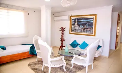 a bedroom with a bed and a table and chairs at Casa lujosa cerca al mar en cartagena in Cartagena de Indias