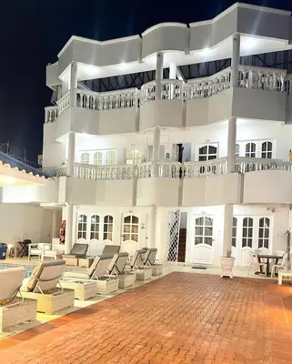 a large white building with chairs and a patio at Casa lujosa cerca al mar en cartagena in Cartagena de Indias