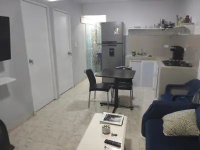 a living room with a table and chairs and a kitchen at Back house gallery in Cartagena de Indias