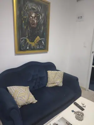 a blue couch in a living room with a painting at Back house gallery in Cartagena de Indias
