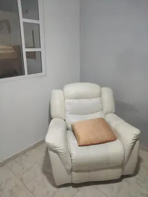 a white leather chair with a brown pillow on it at Back house gallery in Cartagena de Indias